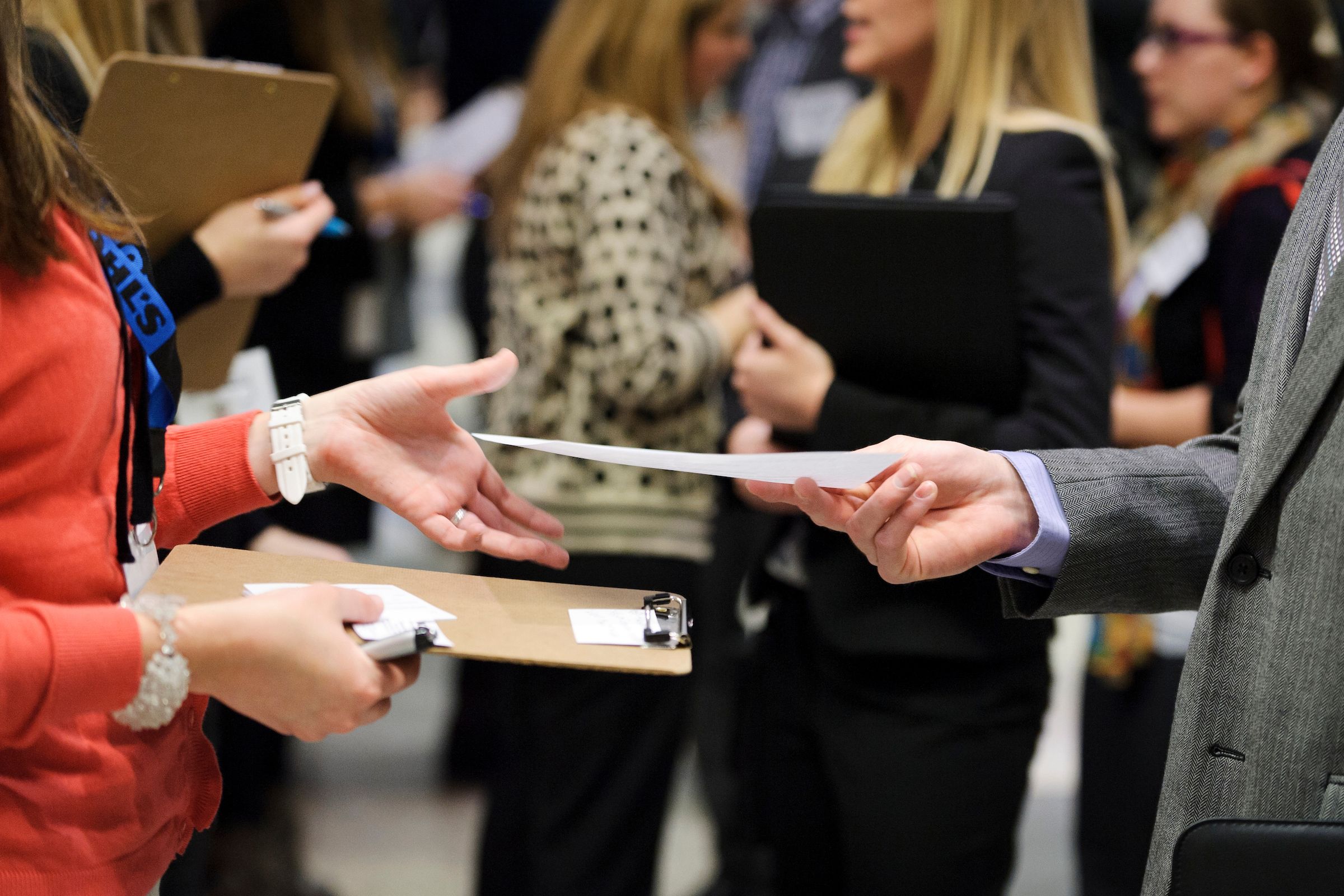 career fair, where a student passses off their resume to a potential employer