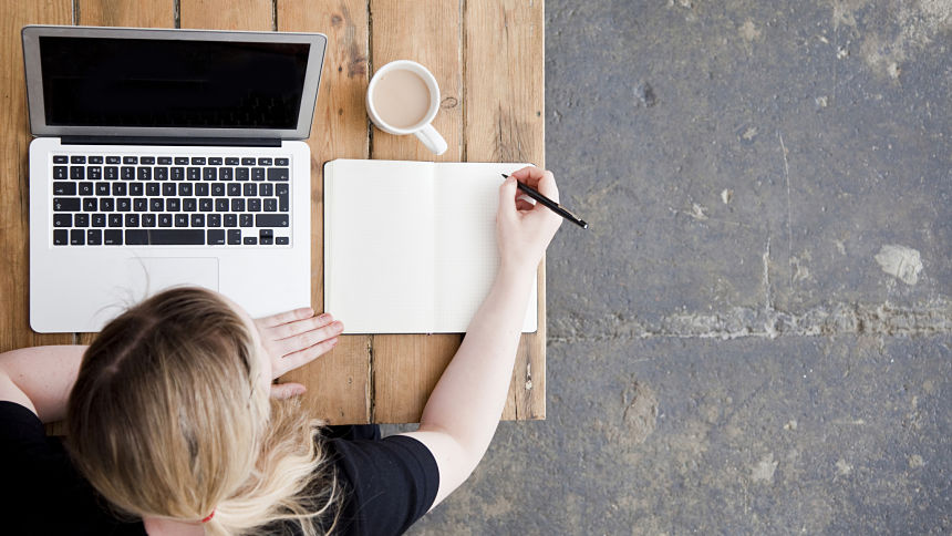 Top view of a woman with laptop and notebook