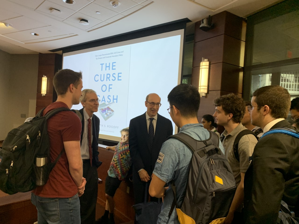 Presenter talks with students after finishing their presentation on their book 'the curse of cash'