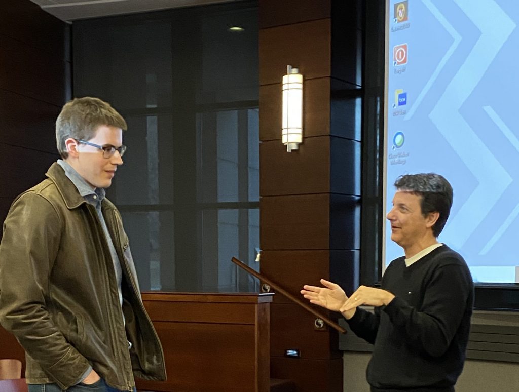speaker talks with student after their presentation