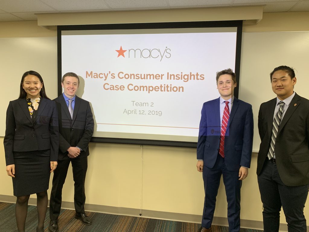 Students stand in front of a screen before their presentation about Macy's consumer insights for the undergraduate case competition