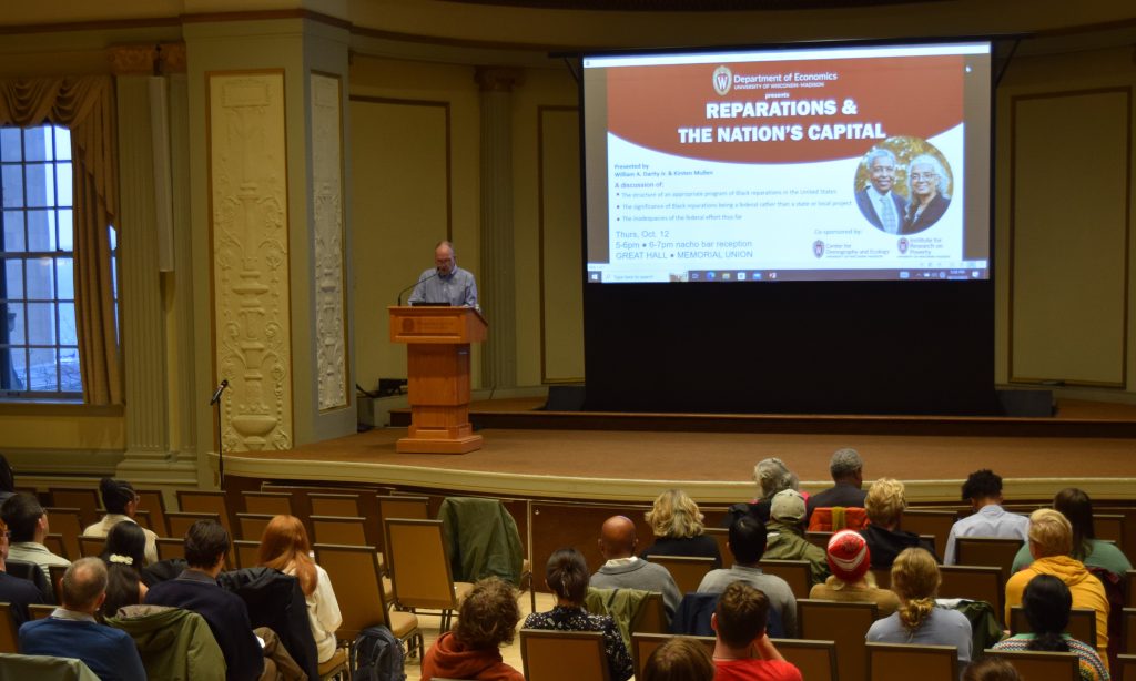 Faculty member introduces event speakers william darity jr and kirsten mullen before their presentation titled reparations & the nations capital